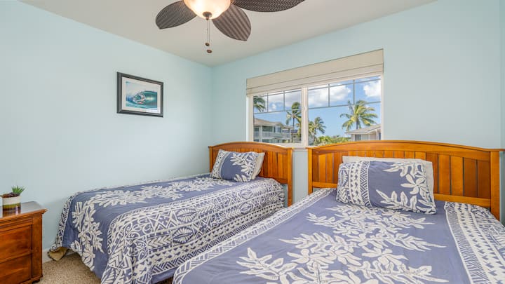 ห้องนอนพร้อมเตียงคู่ 2 หลังและพัดลมเพดาน 