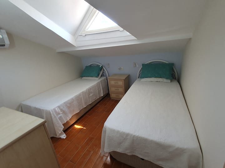 Bed 4, this is a compact room with a sloping ceiling. Aircon. Wall mounted reading lights.