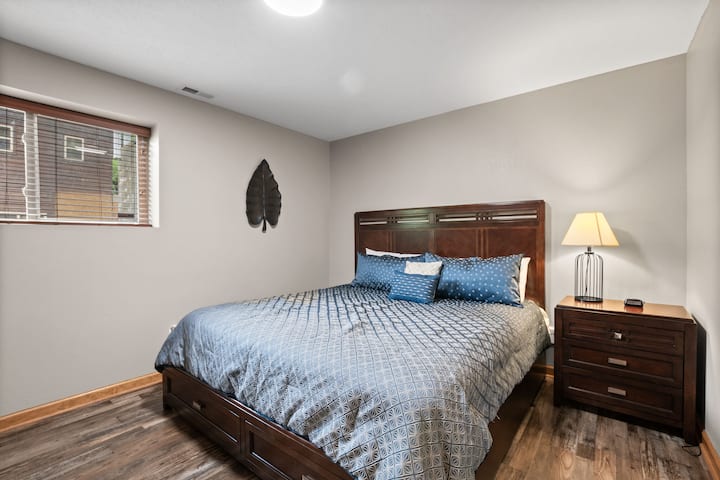 Спална соба со брачен кревет на пониско ниво со паметен телевизор.