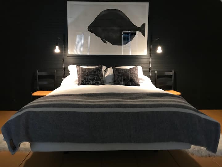 La camera da letto principale con letto matrimoniale regolabile con materasso Tempur-pedic è adiacente a un bagno completo a sinistra e a un servizio lavanderia a destra.