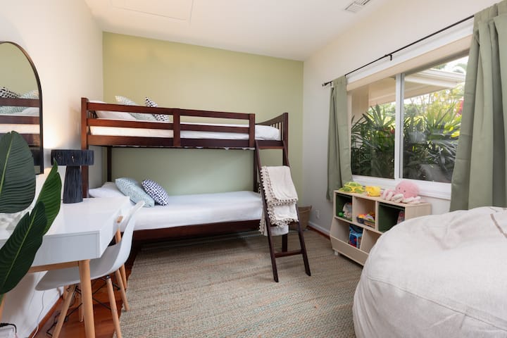 غرفة النوم الرابعة مع سرير بطابقين وألعاب للأطفال ومكتب دراسة للعمل.