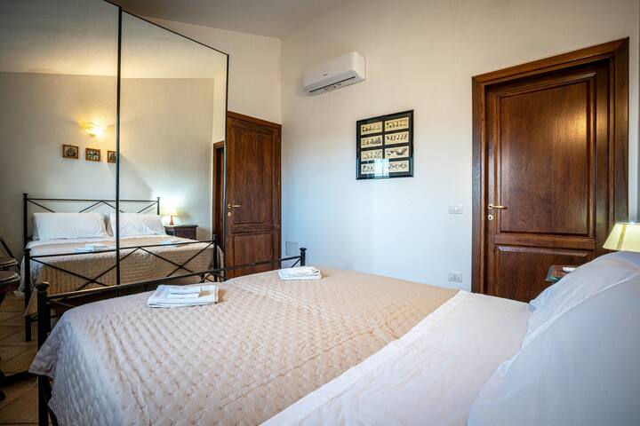 غرفة النوم مع السرير المزدوج، والخزانة مع المرايا والأبواب المنزلقة، وباب الوصول إلى الحمام الخاص وتكييف الهواء، موجودة في كل غرفة 