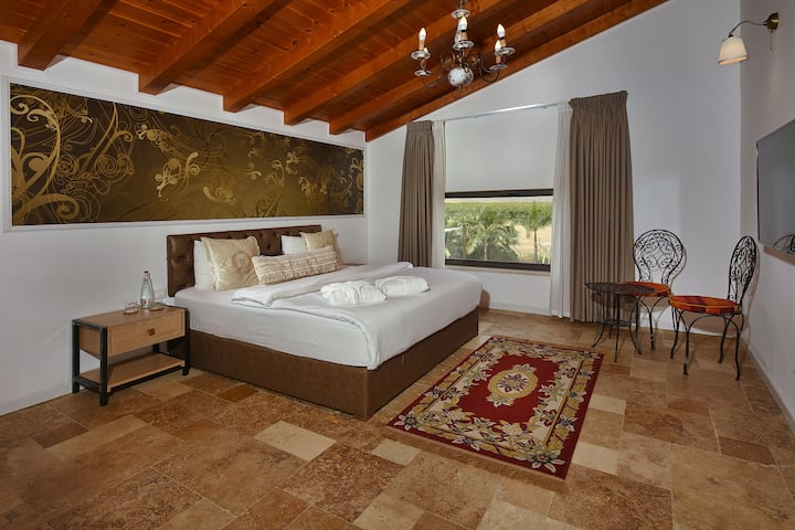Amplia suite de unos 40 metros cuadrados con vistas a los Altos del Golán y a Hermón.
Incluye un gran inodoro y ducha. Cama tamaño king envuelta en ropa de cama cargada. Televisión y sistema multimedia.