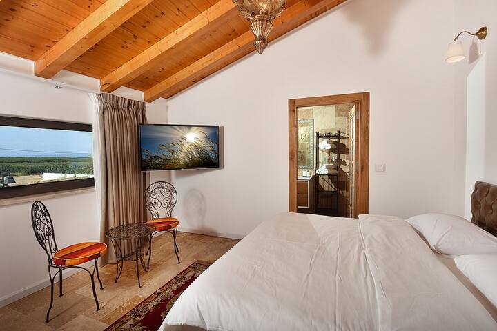 Amplia suite de unos 40 metros cuadrados con vistas a los Altos del Golán y a Hermón.
Incluye un gran inodoro y ducha. Cama tamaño king envuelta en ropa de cama cargada. Televisión y sistema multimedia.