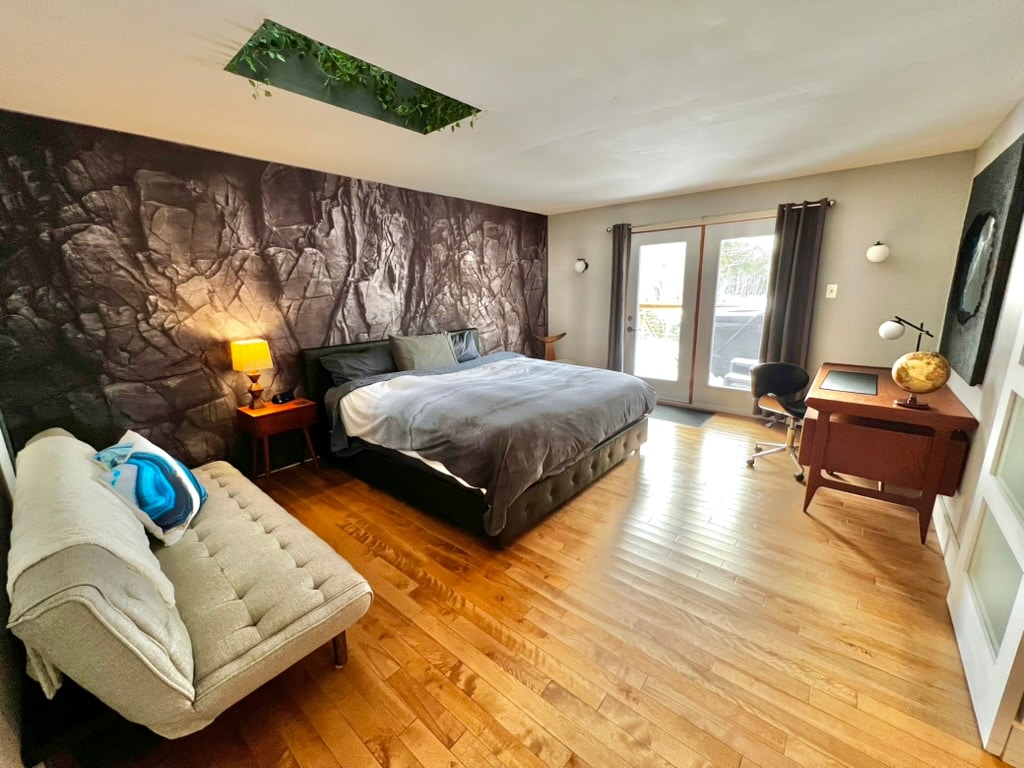 Large master bedroom has a comfortable king bed, convertible futon sofa, antique desk and skylight. With walk-out access to deck and hot tub.