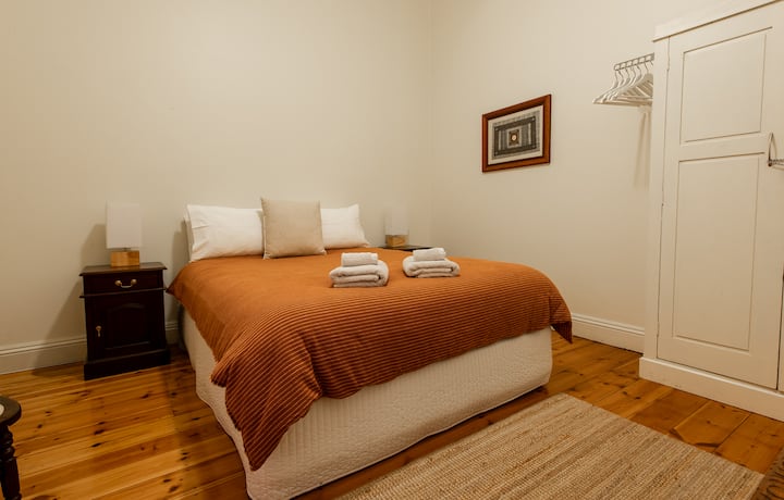 Ez a queen méretű hálószoba mennyezeti ventilátorral, kényelmes matraccal és minőségi ágyneművel is rendelkezik.