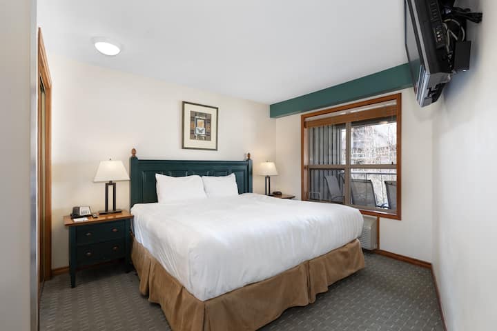 Primárna spálňa s manželskou posteľou King, TV a vlastnou kúpeľňou.