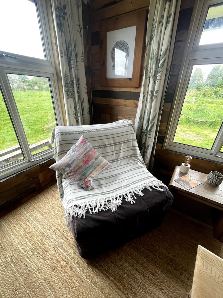 Ky ndenjëse e rehatshme me jastëk ka një kornizë metalike që paloset në një krevat tek shumë të rehatshëm.