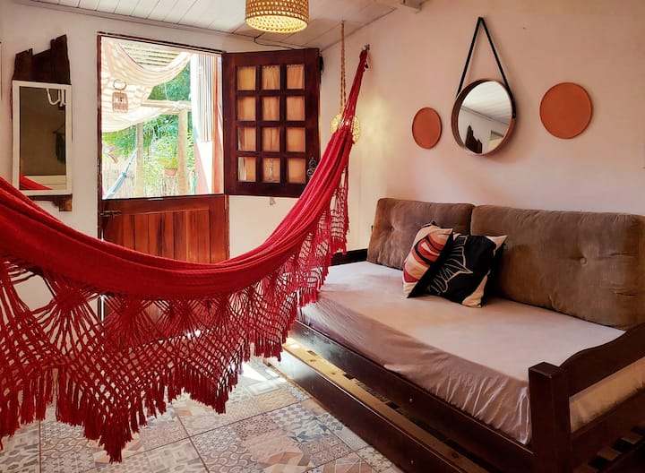 Sala de estar con sofá cama con cama auxiliar, hamaca de descanso y vistas a un sudor y jardín.