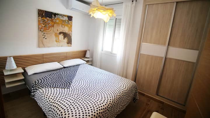 Stor seng, aircondition og vindue med udsigt over havet