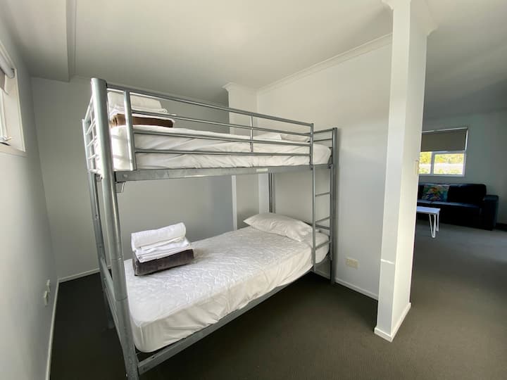 Habitación abierta junto a la sala de estar de arriba con literas.