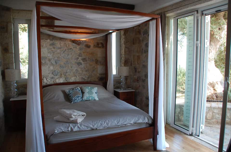 Master bedroom with four-poster bed and terrace doors