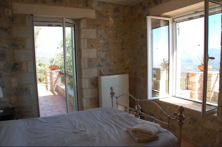 Stone bedroom opening to a private terrace with valley views