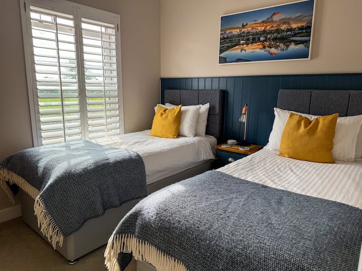 Descansa tranquilo en nuestra habitación doble, donde la comodidad es la llave y el estilo es abundante. Con dos acogedoras camas, una iluminación elegante y una vista que atrae la luz de la mañana, es un refugio perfecto para amigos o familiares.