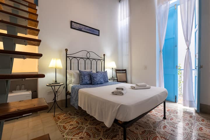 Room with queen bed, stairs to access to the private bathroom.