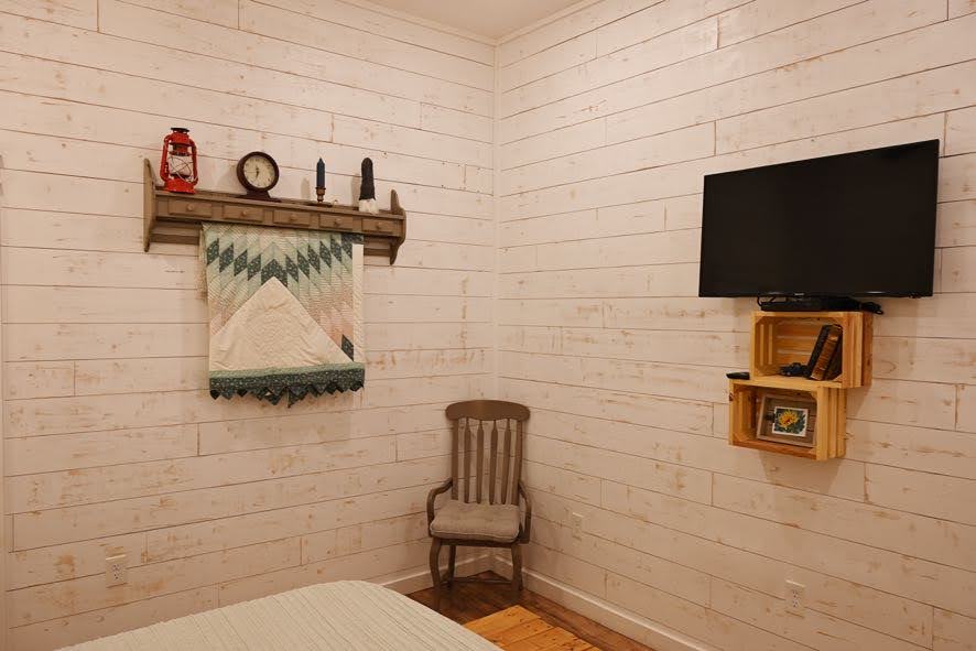 Спална соба во апартман со телевизор и DVD плеер.