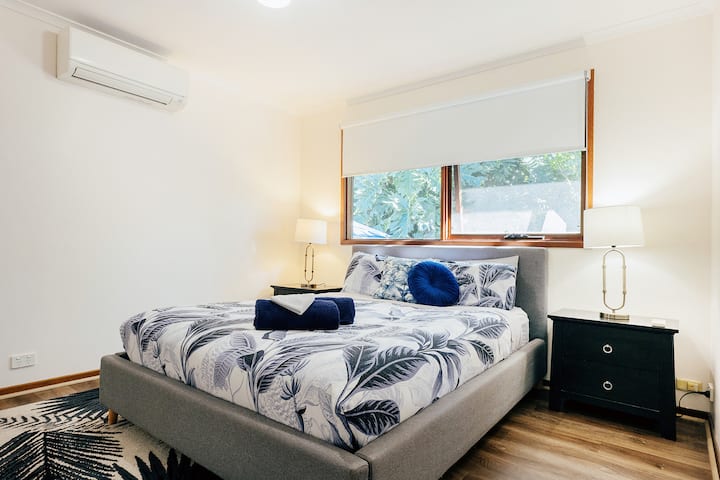 ห้องนอนหลักพร้อมเตียงควีนไซส์และห้องแต่งตัวที่เหมาะสำหรับตั้งเตียงเด็ก เครื่องปรับอากาศและจุดเสียบปลั๊กสำหรับอุปกรณ์อิเล็กทรอนิกส์