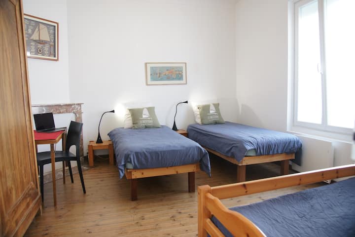 Habitación con parquet con 3 camas de 80 que también pueden hacer 1 cama de 160 y 1 cama de 80.