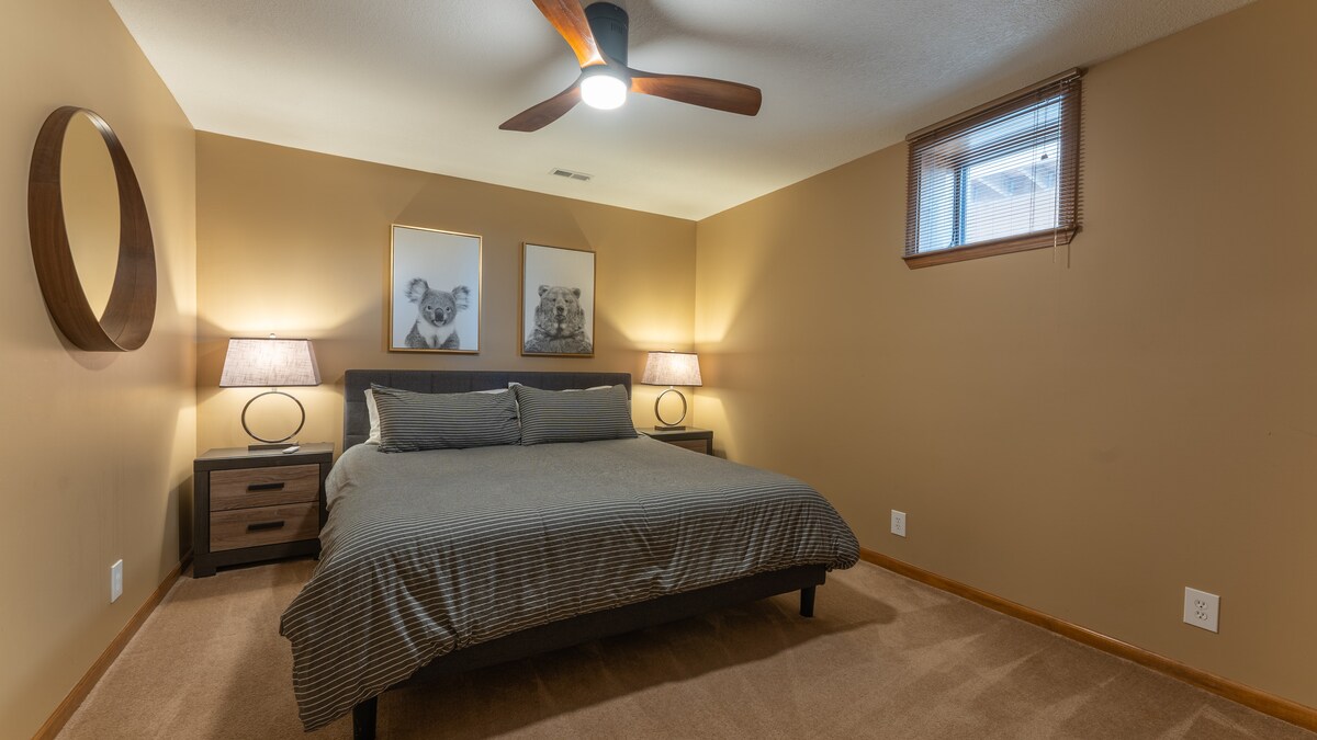 Spálňa v suteréne s manželskou posteľou veľkosti King a šatníkom.