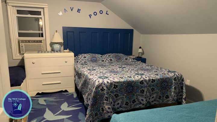 This second floor Wave Pool bedroom has a queen and three single beds, two windows, perfect for an entire family to enjoy, or have all the children sleep in this one large bedroom, with two night stands with charging ports for mobile devices. 