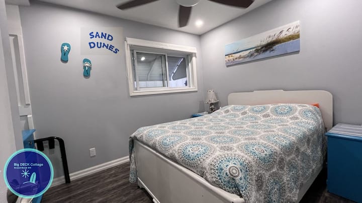 The Sand Dudes bedroom on the main floor is beside the main floor bathroom, and has a double size bed, single closet, large window with an outside awning, and two night stands with charging ports for mobile devices. 