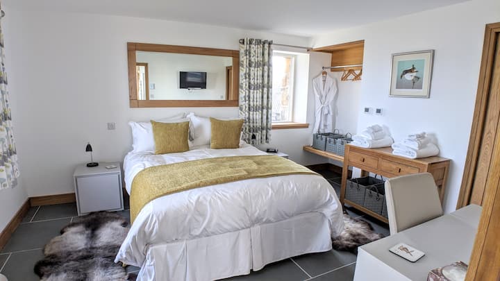 Დიდი ზომის საწოლი სმარტ-ტელევიზორით, ტანსაცმლის ჩამოსაკიდი და სათავსოები, მარჯვნივ მდებარე კარიდან „სველი ოთახი“.