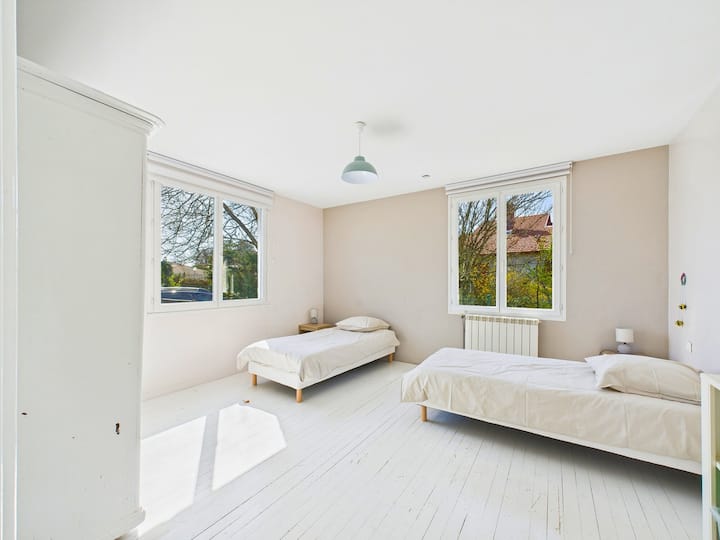 Një dhomë gjumi e tretë e madhe dhe e ndritshme me dy krevate tek.