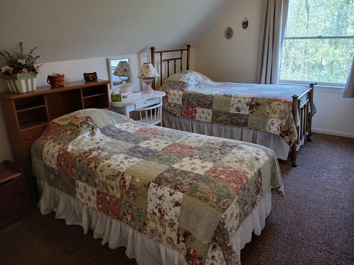 غرفة نوم خلفية بسريرين مفردين.