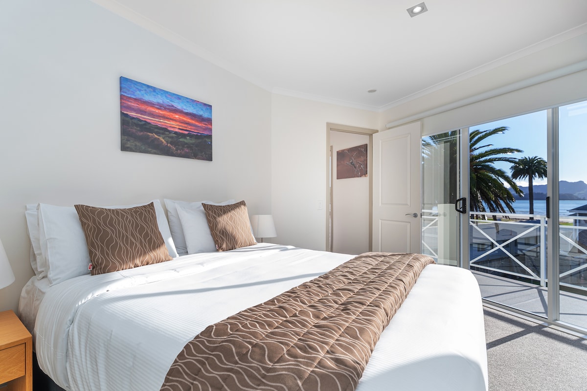 Dormitorio principal con cama tamaño queen y vistas al agua