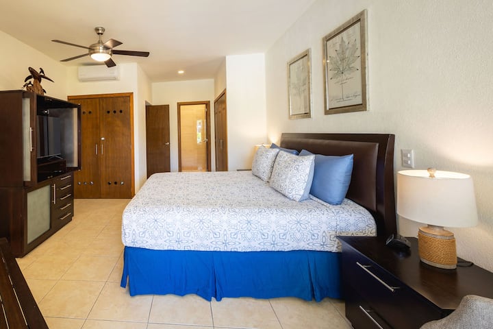 Spavaća soba s velikim bračnim krevetom i klima-uređajem i stropnim ventilatorima