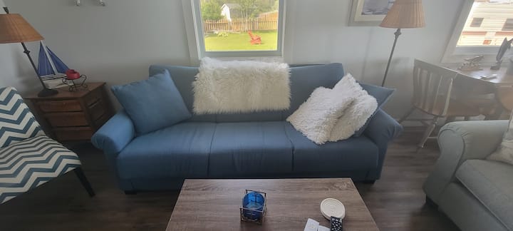 Il soggiorno ospita un divano letto con cuscini e biancheria da letto in più