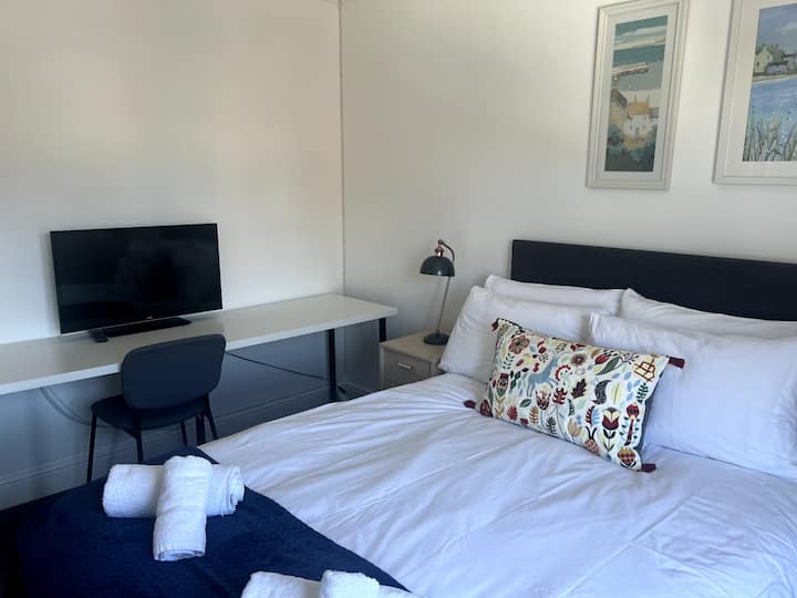 Dormitorio principal con TV y baño