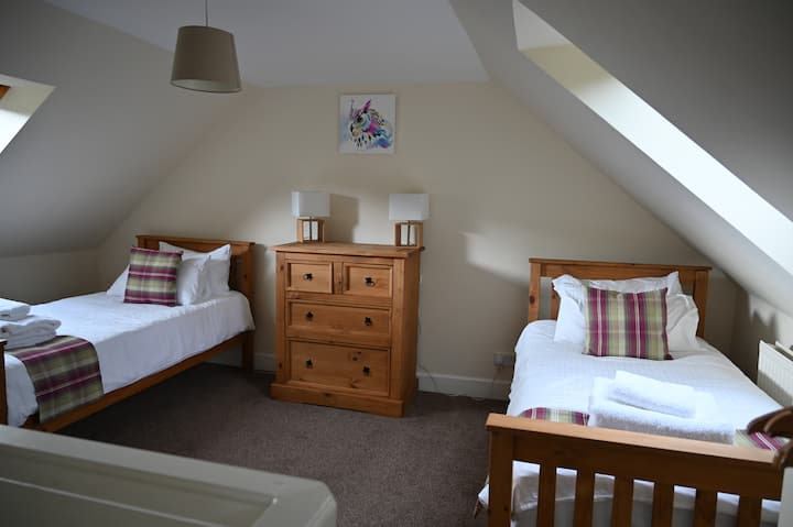 В горната част на стълбите има светла стая с 2 отделни легла, водеща към съседна двойна стая.