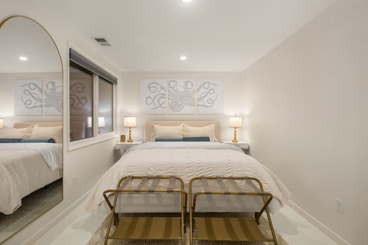 Cama tamaño queen, dos mesas laterales pequeñas, espejo de cuerpo entero, iluminación enlatada, así como persianas opacas para las personas que duermen el día. 