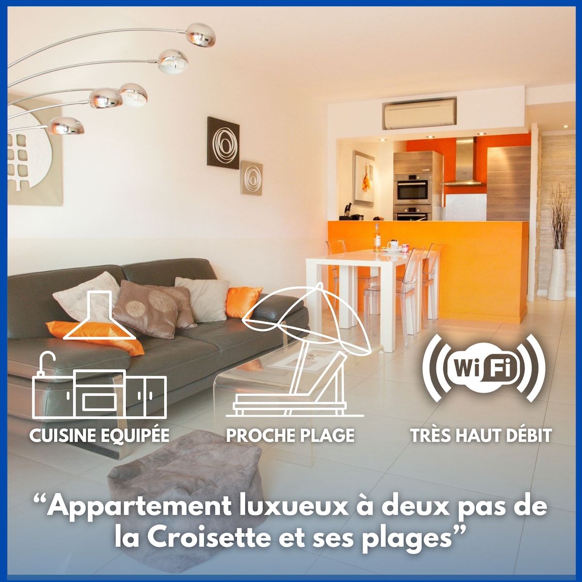 A modern living space is showcased, featuring a comfortable sofa with bright orange accents. Natural light floods through large windows, illuminating the sleek, open-plan kitchen in the background. The dining area is visible, offering a spacious table paired with stylish chairs.