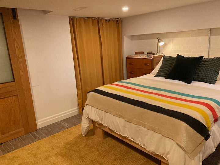 Katil Queen yang selesa di bilik tidur. Almari di belakang langsir. 