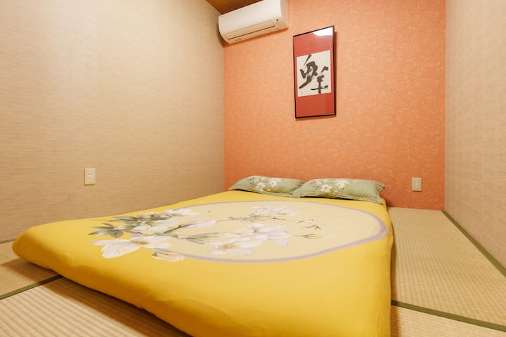 Værelset er et soveværelse i japansk tatamistil med en 1,5 meter bred madras til op til to personer.Tatamigulvet er blødt, velegnet til at gå barfodet, samt giver et behageligt greb til at sove.Væggene i rummet er designet med lavris og varm orange, og der hænger kalligrafi og malerier, hvilket skaber en unik atmosfære af traditionel og moderne fusion.Der er et delt klimaanlæg øverst, der understøtter både køling og opvarmning, hvilket er velegnet til alle årstider.Boligens indretning er kompakt og rolig, velegnet til par, venner eller bare én person til at slappe af.Det enkle design og temperaturen giver rejsende mulighed for at opleve roen og genopretningen af den japanske levende kultur, mens de er væk fra det travle liv.