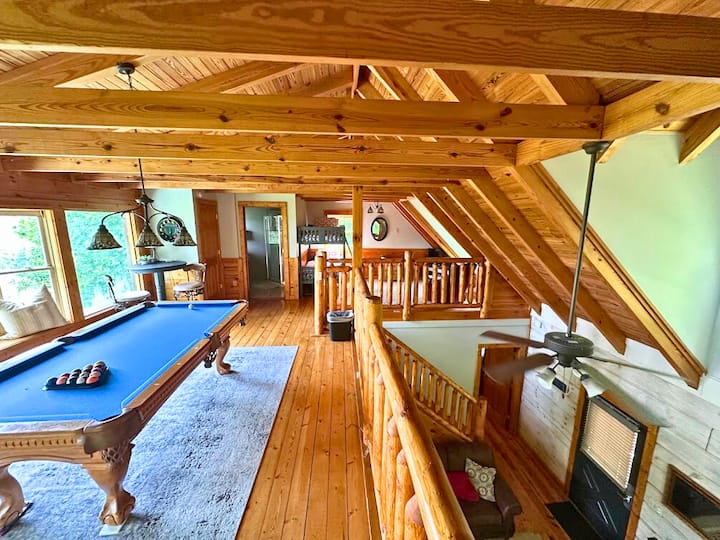 شقة علوية مع طاولة بلياردو وركن قراءة مريح بجانب النافذة.