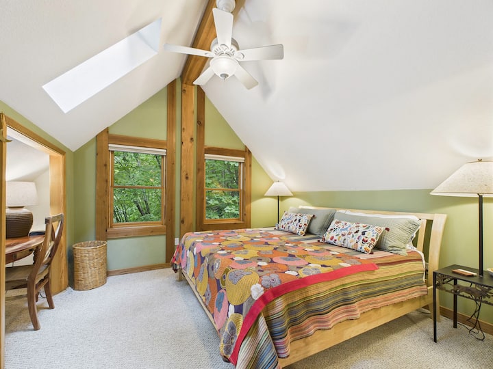 Suite loft colorée avec un lit king incroyablement confortable, un bureau et une salle de bain complète. C'est comme une cabane dans les arbres luxueuse et luxuriante!