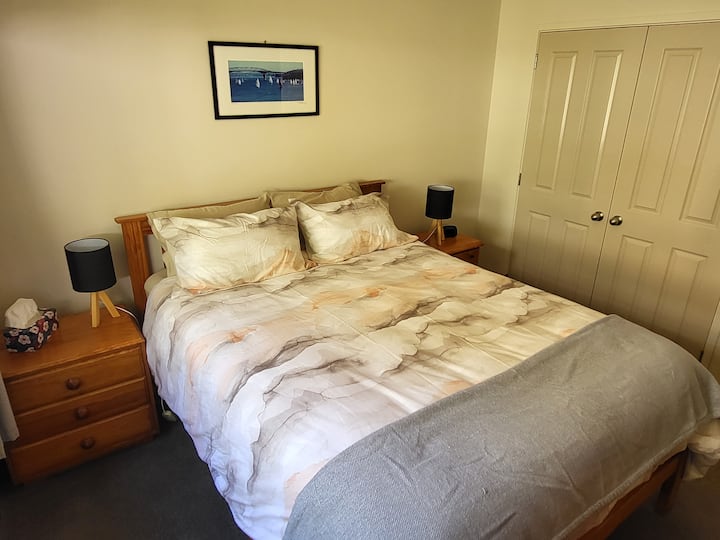 Lit queen size avec deux tables d'appoint et lampes. Plus une commode pour grand garçon. Et grand placard avec oreillers et couvertures supplémentaires si nécessaire