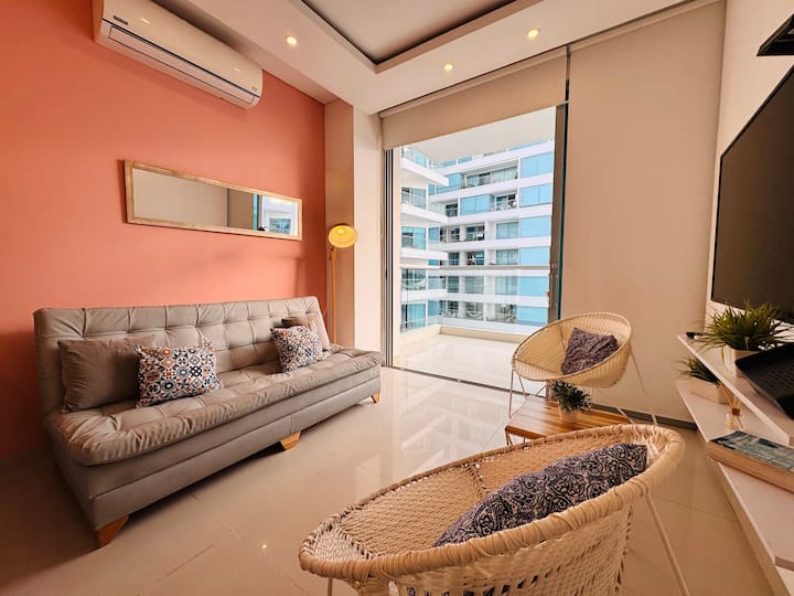 Sala luminosa y moderna con asientos acogedores y ventanas del suelo al techo.