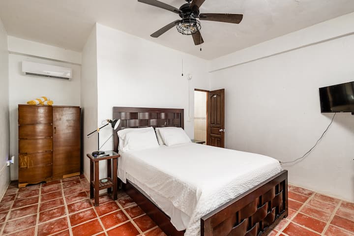 Bedroom 3 features a comfy queen bed, private ensuite bathroom, Smart TV for streaming, and a brand-new AC unit to keep things cool. An armoire provides space to unpack and settle in. French doors open directly onto the patio for easy outdoor access.