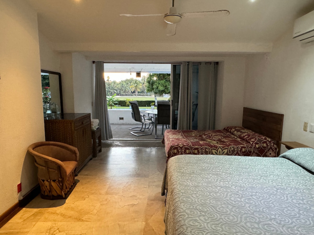 חדר שינה עם דלתות הזזה מזכוכית למרפסת המשקיפה על הבריכה. חדר רחצה ושירותים פרטי.