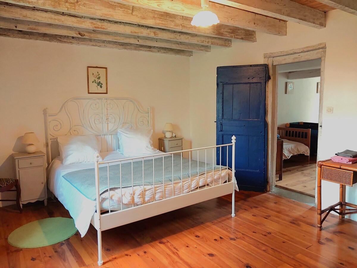 Spacious master bedroom with parquet and exposed beams gives right to its private bathroom with shower and bath.