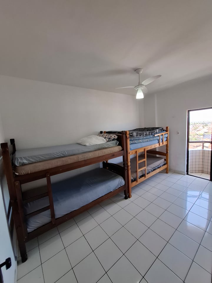 Habitación 2 con 2 literas y balcón con vista lateral de pantalla del edificio ( montañas, ciudad y mar)