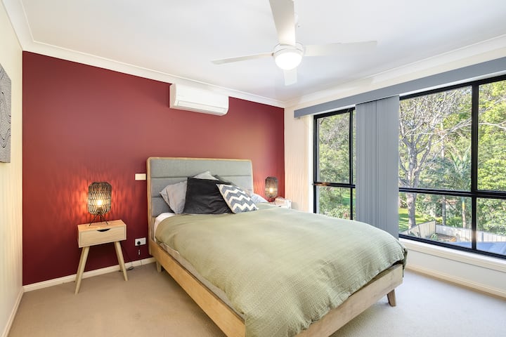 主卧配有绿树成荫的景观、套房、风扇和空调以及步入式衣柜 