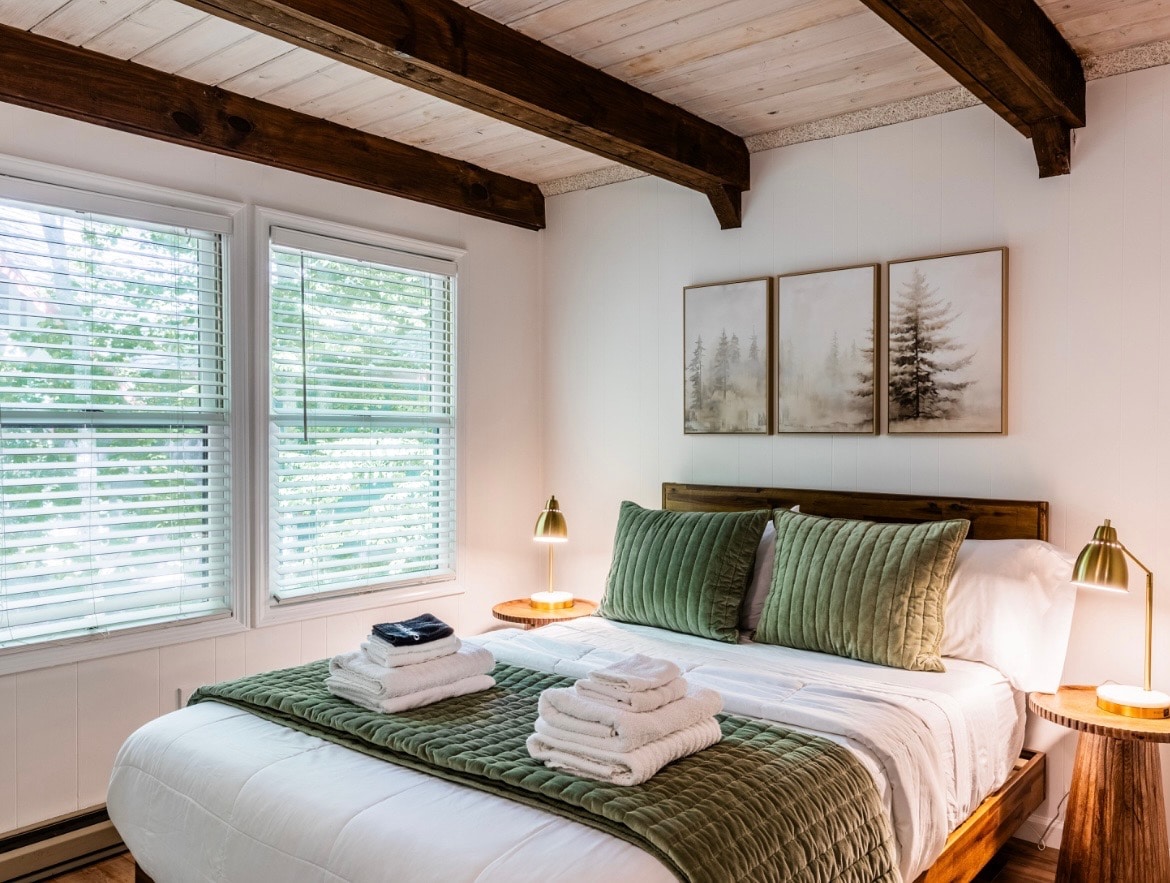 Príďte si oddýchnuť do spálne Forrest Main Level Queen s luxusnou posteľnou bielizňou, novým matracom, nabíjacími lampami na odkladacom stolíku pre elektroniku a stropom na jazyk a drážku s trámami.