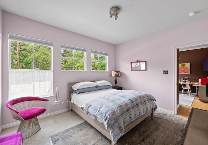 Bedroom with dresser, closet for hanging, floor fam with remote, blackout curtains, solar shades. Nice view of neighborhood and entry garden below. 