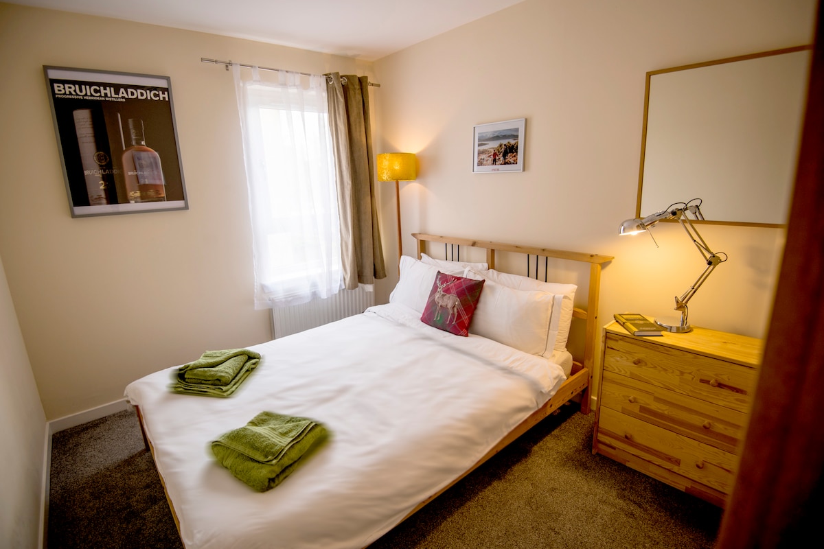 Slaapkamer met tweepersoonsbed naast woonruimtes, ingebouwde kledingkast, laden en nachtlampje.
Er is een klein toilet/wastafel op dezelfde verdieping - zie indelingsplannen 