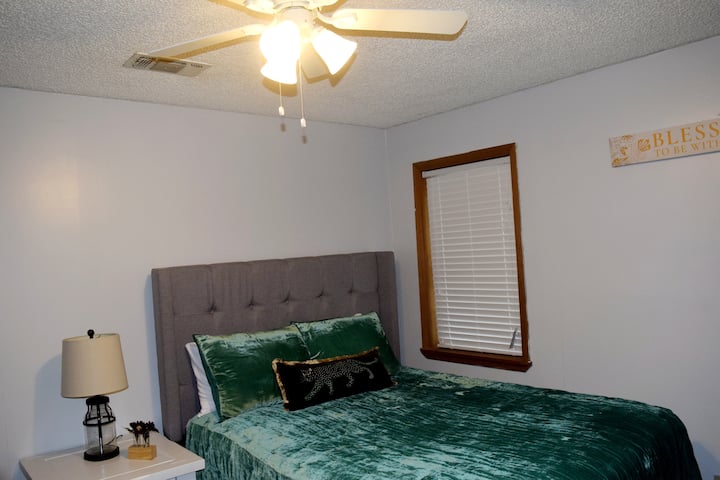 Დედოფლის საწოლი დიდი კარადით, წიგნების თაროთი და ტელევიზორით.